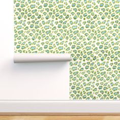 an animal print wallpaper with green and blue spots on the wall next to a white door