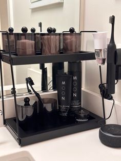 a bathroom sink with soap dispensers and toothbrushes on the shelf