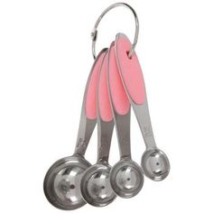 three measuring spoons with pink handles are hanging from the hooks on a white background