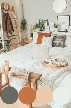 a bedroom with white bedding, pillows and pictures on the wall next to it