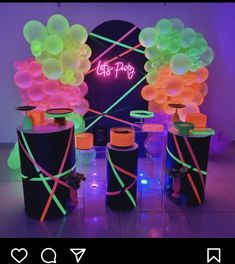 three black trash cans with neon lights and balloons on the top one is filled with water