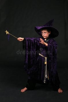 a little boy dressed as a wizard holding a wand