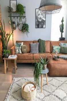 a living room filled with lots of furniture and plants on top of a white rug