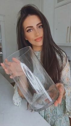 a woman holding up a plastic container in the kitchen