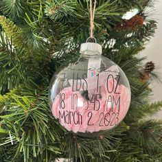 a christmas ornament hanging from a tree with the date and time on it