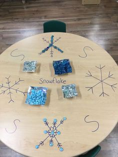 a table with snowflakes on it and some blue rocks in the middle that says snowflake