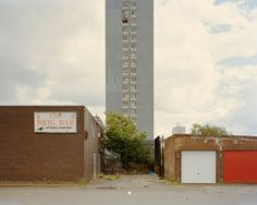 an empty parking lot in front of a tall building with a sign on it that says brick bar