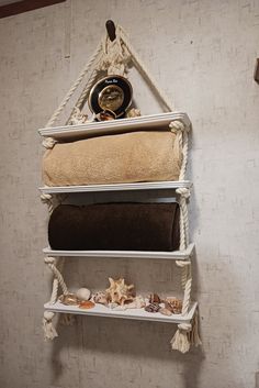 three shelves with towels and seashells hanging on the wall next to each other