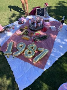 the table is set up for an event with pink and gold decorations on it, including letters that spell out the number twenty