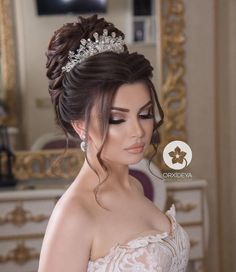 a woman wearing a tiara in front of a mirror with her hair pulled back