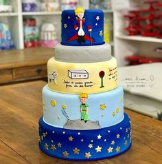 three tiered cake decorated with cartoon characters on it's sides and stars around the edges