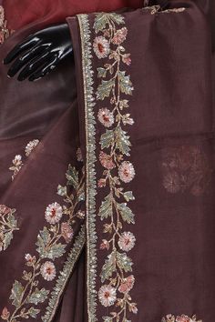 an embroidered maroon sari with floral embroidery on the border