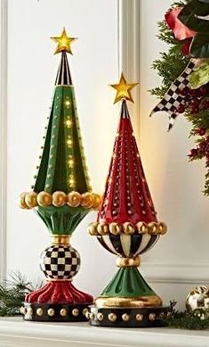 three christmas trees sitting on top of a mantle