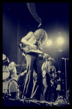 a man standing on top of a stage holding a guitar