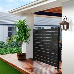 an open door on the side of a house next to a potted plant and grass