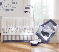 a baby's room decorated in blue and white with fish decals on the wall