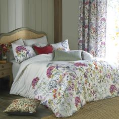 a bedroom with floral bedding and pillows