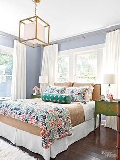 a bed room with a neatly made bed and a chandelier hanging from the ceiling