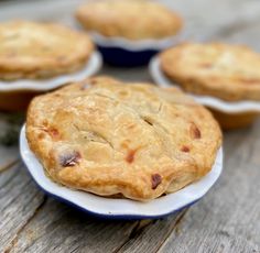 several small pies sitting on top of a wooden table next to eachother