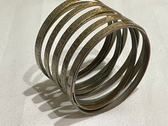 Found this gorgeous bracelet in The Netherlands! I hope the pictures and videos capture the beautiful colours well. It's base is silver but it has a coppery gold reflect that catches warm light. Circumference approx 21cm Elegant Silver-colored Copper Cuff Bracelet, Nickel-free Unique Metal Bangle, Unique Nickel-free Metal Bangle, Handmade Silver Wrap Bracelet, Hand Wrapped Silver Copper Bangle, Unique Handmade Silver Wrap Bracelet, Vintage Hand Wrapped Wrap Bracelet Gift, Vintage Hand Wrapped Wrap Bracelet For Gift, Nickel-free Copper Bracelets In Silver