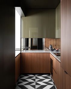 a kitchen with black and white flooring next to a counter top on a tiled floor