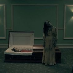 a woman standing next to a bed in a room