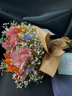 a bouquet of flowers sitting on top of a car seat