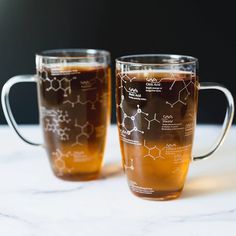 two mugs filled with liquid sitting on top of a table