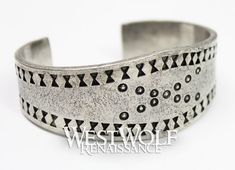 This beautiful Viking bracelet is historically accurate and modeled after a silver Viking bracelet found in the Curedale hoard at Lancashire, England in 1840. This type of stamped design was common in Viking culture, and solid silver bracelets such as this would have been used both as bullion and as jewelry. This particular bracelet we offer has been handmade of finely polished silver pewter and recreated from the archaeological find in every detail. The metal of this bracelet is completely safe Medieval Engraved Bracelet Jewelry, Medieval Style Silver Bracelet Gift, Hand Forged Silver Viking Jewelry, Viking Style Silver Bangle Bracelet, Silver Viking Bracelet Engraved, Vintage Silver Jewelry For Costume Or Role-play, Medieval Norway, Lancashire England, Solid Silver Bracelets