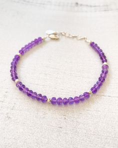 February's birthstone shimmers in this handcrafted beaded bracelet. Beautifully faceted amethyst gems are accented with bright sterling silver beads. An extender chain allows for an adjustable fit. Bracelet length: 7.25 inches plus 1-inch extender Materials: amethyst beads, sterling silver components Elegant Rondelle Crystal Bracelet With Gemstone Beads, Elegant Rondelle Crystal Bracelet With Spacer Beads, Adjustable Purple Rondelle Beaded Bracelets, Amethyst Beaded Bracelets With Spacer Beads As Gift, Purple Rondelle Beaded Bracelets As Gift, Sterling Silver Rondelle Gemstone Beaded Bracelets, Elegant Rondelle Faceted Beads Crystal Bracelet, Purple Sterling Silver Beaded Bracelets With Round Beads, Elegant Crystal Rondelle Bracelet With Faceted Beads