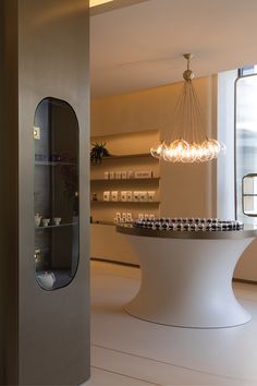 a large white table in a room with shelves on the wall and a chandelier hanging from the ceiling