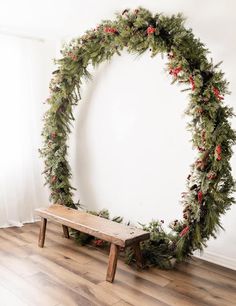 a wooden bench sitting in front of a christmas wreath