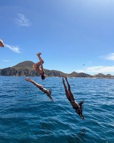 two people diving into the ocean from a boat