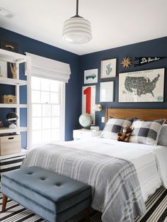 a bedroom decorated in blue and white with pictures on the wall above the headboard