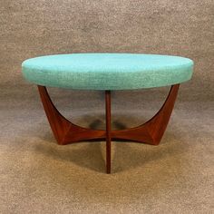 a blue ottoman sitting on top of a carpeted floor