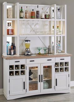 a white cabinet filled with lots of bottles and glasses