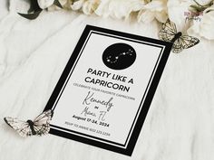 a party like a capricorn card with butterflies on it next to some flowers