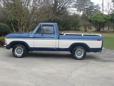 a blue and white truck parked in a parking lot