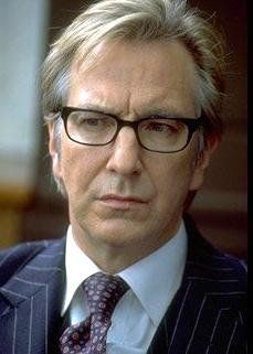 a man wearing glasses and a suit looks at the camera