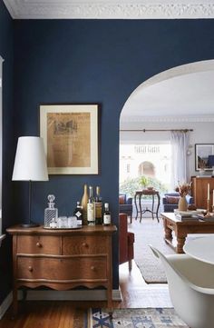 a living room with blue walls and furniture in the corner, along with a bathtub