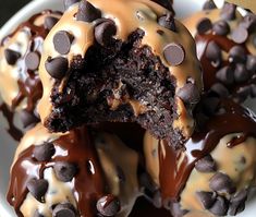 chocolate covered donuts are sitting on a plate with chocolate chips and drizzles