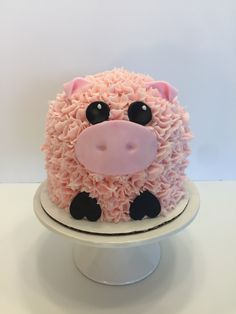 a cake with pink frosting and black decorations