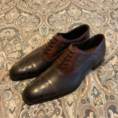 Brand New, New Worn, No Defects. Beautiful Style Oxfords, Made In Spain. Sold Out And Hard To Find Style And Color. Mezlan Checkerboard Leather Oxfords. Mens Sz 9 Medium. Official Color Is Black Burgundy But Is More Like Copper Black Brown. No Bo. Product Details On Last Photo. Please Check Your Sizing Accordingly To The Brand. Make Offers!! Designer Brown Wingtip Leather Shoes, Designer Brown Leather Shoes With Brogue Detailing, Luxury Brown Leather Shoes With Goodyear Welt Construction, Brown Leather Cap Toe Shoes With Perforated Toe Box, Luxury Brown Oxfords, Designer Brown Leather Business Shoes, Brown Dress Shoes With Goodyear Welt Construction, Brown Leather Oxfords With Perforated Toe Box, Masculine Brown Leather Oxfords