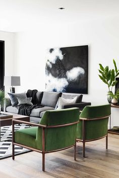 a living room filled with furniture and a painting on the wall