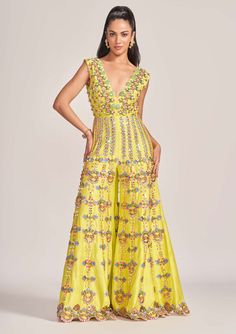 Editor's Note The classic papa don’t preach jumpsuit silhouette with linear motif placement of 3-D metallic embellishments strung along with bead and pearl details. Color: Yellow Fabric: Matka Silk Sleeve type: Sleeveless Component: Jumpsuit Occasion: Haldi mehndi and Wedding Guest Care: Dry clean only Disclaimer: product color may slightly vary due to photographic lighting sources or your monitor setting. Note: this product is exclusively hand crafted using multiple techniques, individually han Festive Floor-length Jumpsuits And Rompers, Festive Maxi Length Jumpsuits And Rompers, Embroidered Fitted Jumpsuits And Rompers For Festive Occasions, Festive Embroidered Fitted Jumpsuits And Rompers, Fitted Embroidered Jumpsuit For Festive Occasions, Festive Floor-length Jumpsuits And Rompers For Summer, Festive Embellished Floor-length Jumpsuits And Rompers, Elegant Summer Festive Jumpsuits And Rompers, Elegant Sleeveless Jumpsuits And Rompers For Festive Occasions