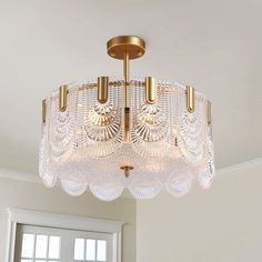 a chandelier hanging from the ceiling in a room with white walls and windows