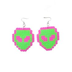 a pair of pink and green earrings with pixeles on the front, one is shaped like a face