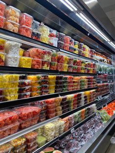 an aisle in a grocery store filled with fruits and vegetables