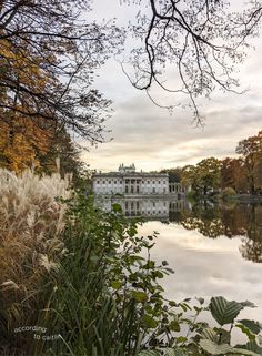 a large white house sitting on top of a lake