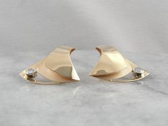 "These bold designer earrings have elegant swaths of polished yellow gold floating over a textured underlayment. A large accent diamond, weighing in at over a quarter carat, adorns the base of these abstract triangular stud earrings, giving this piece another element of sophistication. Metal: 14K Yellow Gold Gem: 2 Diamonds totaling 0.56 Carats, VS in Clarity, G in Color. Earrings Length: 30.5 mm Earring Width: 27.0 mm Marks: \"RH 14K\" Inscribed on the back of the earring SKU #: PHDW0Z-N Each p Polished Yellow Gold Diamond Earrings For Evening, Luxury Diamond Earrings For Anniversary With Polished Finish, Modern Diamond Cut Diamond Earrings For Evening, Modern 14k Gold Earrings With Diamond Accents, Modern Diamond Accent Earrings For Anniversary, Luxury Polished Diamond Earrings For Anniversary, Modern Diamond Earrings With Accents For Evening, Modern Diamond Cut Earrings For Evening, Formal Fine Jewelry Diamond Earrings With Polished Finish